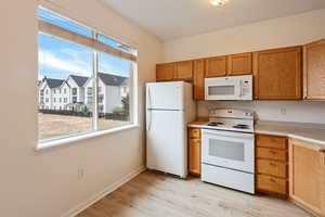 Kitchen featuring white appliances and light wood-type flooring