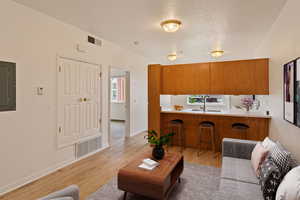 Living room with sink and light hardwood / wood-style floors