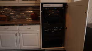 Kitchen featuring backsplash and white cabinets