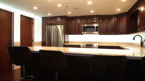 Kitchen featuring stainless steel appliances, sink, dark hardwood / wood-style floors, and dark brown cabinetryhttps://www.utahrealestate.com/lip/photo/listno/2006057#