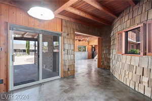 Interior space with a wealth of natural light, beamed ceiling, concrete floors, and wood ceiling