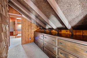 Bonus room featuring wooden walls and vaulted ceiling