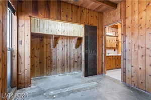 Mudroom featuring beam ceiling, wood walls, and wooden ceiling