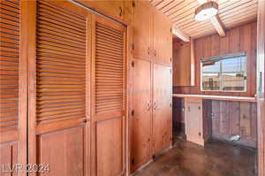 Hall featuring beamed ceiling, wooden ceiling, and wooden walls