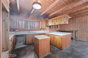 Kitchen featuring sink, beam ceiling, wood ceiling, and a kitchen island