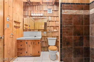 Bathroom featuring tile floors, vanity, and toilet