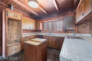 Kitchen with beam ceiling, wooden ceiling, and sink