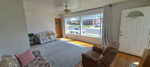 Living room with ceiling fan and light hardwood / wood-style floors