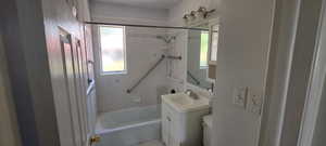 Full bathroom featuring vanity, toilet, tiled shower / bath combo, and a healthy amount of sunlight