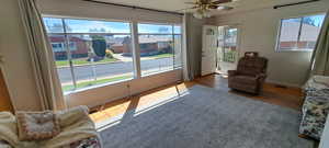 Living area with ceiling fan and dark hardwood / wood-style flooring