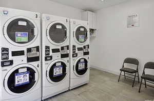 Laundry area featuring washer and clothes dryer, stacked washer and clothes dryer, and light tile flooring