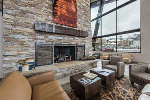 Living room with a high ceiling and a stone fireplace