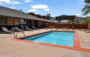 View of pool with a pergola and a patio area