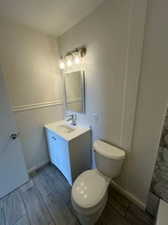 Bathroom with vanity with extensive cabinet space and toilet