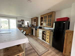 Kitchen with black refrigerator and wood-type flooring