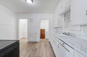 Kitchen featuring white cabinetry, light hardwood / wood-style flooring, sink, tasteful backsplash, and dishwasher