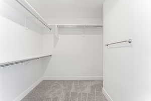 Spacious closet with light colored carpet