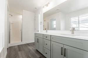 Bathroom with vanity, hardwood / wood-style flooring, and an enclosed shower