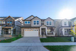 View of front of home with a front yard, a garage, and a porch