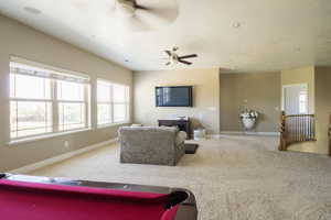 Carpeted living room featuring ceiling fan