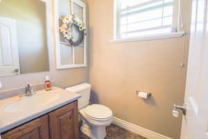 Bathroom featuring tile flooring, vanity, and toilet