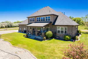 Rear view of house featuring central AC unit and a yard