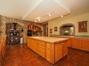 Kitchen tile floors, stone arches, wood-burning stove