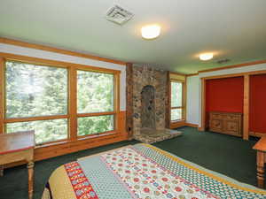 Bedroom 3 with floor-to-ceiling stone fireplace and windows