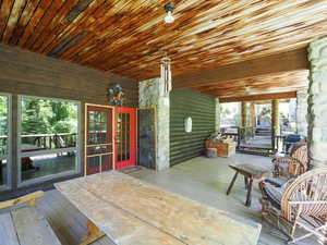 Porch entrance, river stone, exposed wood beams, logs