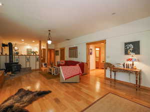 Expansive basement living room featuring wood-burning stove, and entrance to primary basement suite