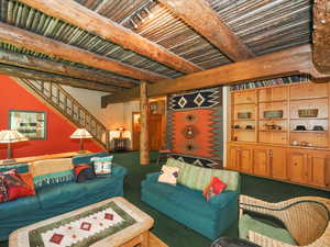 Wood built-ins, exposed wooden beam, and log ceiling views in family room