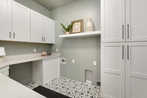 Laundry area featuring cabinets, light tile flooring, and washer hookup