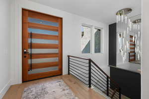 Front door and staircase with oversized custom mirror wall.