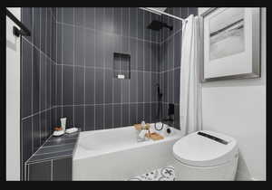 Bathroom with heated tile flooring, bidet and beautiful tile work.