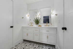 Bathroom with heated tile flooring, double sink, and large vanity