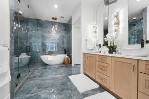 Bathroom featuring double sink, shower with separate bathtub, tile floors, tile walls, and oversized vanity