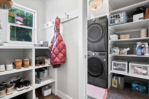 Washroom featuring tile floors and stacked washer / drying machine