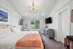 Bedroom featuring vaulted ceiling, an inviting chandelier, and carpet floors