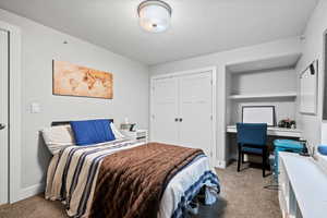 Bedroom with light carpet and a closet