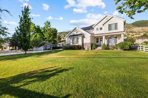 The house is set back from main street. View of front of house with a front lawn and a porch