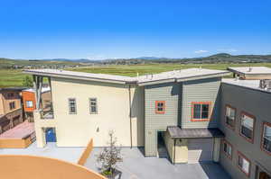 Back of house with a garage and a mountain view