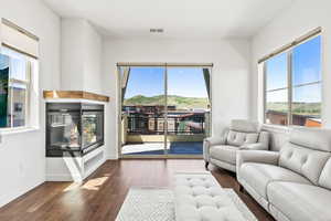 Living room with a multi sided fireplace and dark hardwood / wood-style flooring