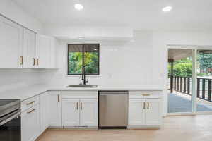 Kitchen with a wealth of natural light, backsplash, light hardwood / wood-style flooring, and stainless steel appliances