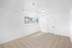 Spare room with carpet flooring and a textured ceiling