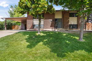 View of front of house featuring a carport and a front lawn