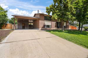 View of front of house with a front lawn and a carport