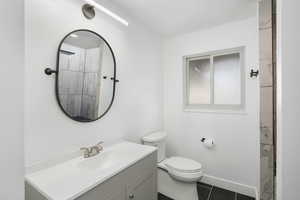 Bathroom with tile flooring, toilet, and vanity