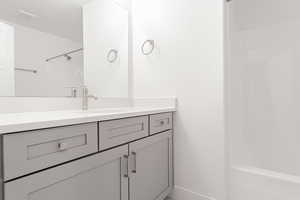 Bathroom with vanity, a textured ceiling, and bathing tub / shower combination