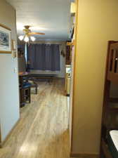 Living room featuring a baseboard heating unit, ceiling fan, and hardwood / wood-style flooring