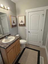 Bathroom featuring tile patterned flooring, vanity, and toilet